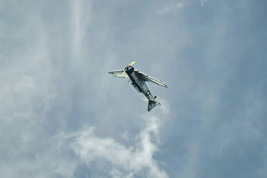 Oldtimer im steilen Steigflug vor Wolken